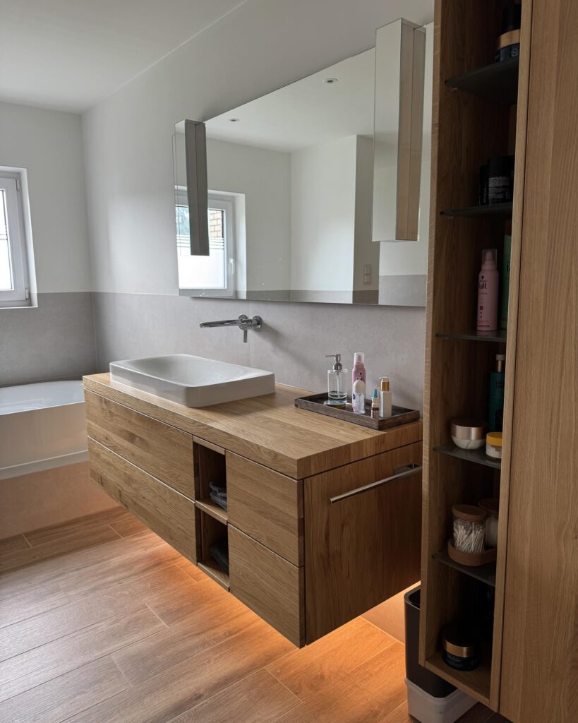 Maßgefertigter Holz-Waschtischunterschrank mit indirekter Beleuchtung und Aufsatzbecken – Schreinerei Pass-Genau Pulheim.