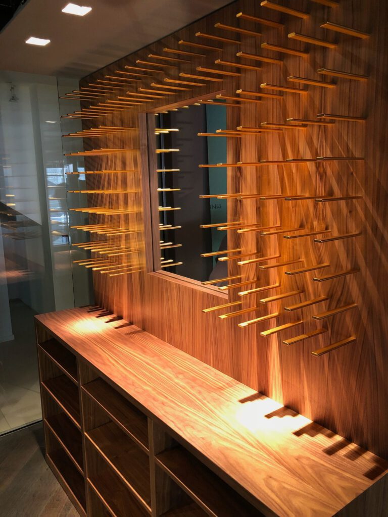 Maßgefertigte Wandgarderobe aus Echtholz mit integriertem Spiegel und Holzstiften für Gastronomie oder Flur.